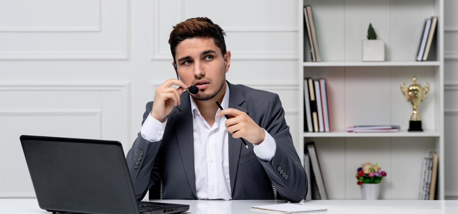 Sales professional conducting a focused discovery call with a headset and laptop, demonstrating active listening and thoughtul questioning - key elements of a great sales discovery call.