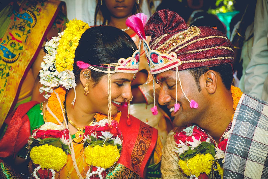 Free Smiling couple in colorful traditional attire during a vibrant Indian wedding ceremony. Stock Photo