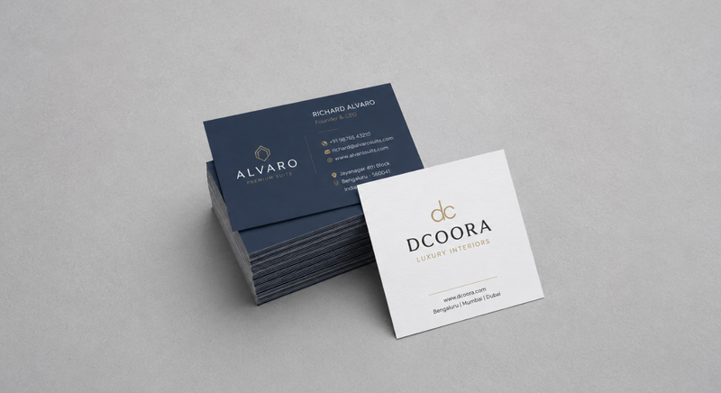 Stack of dark blue business cards paired with a white square business card.
