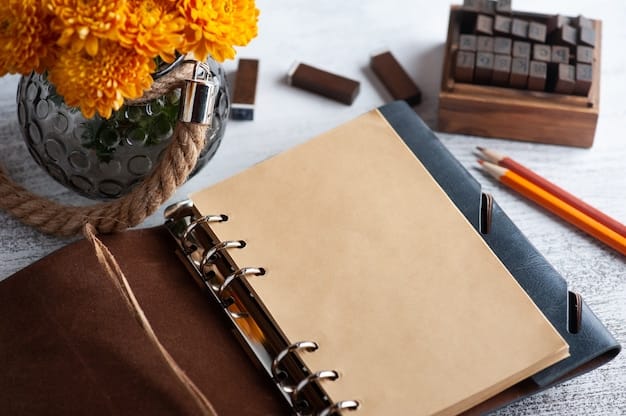 Empty open craft notebook and orange chrysanthemum flowers on rustic table.