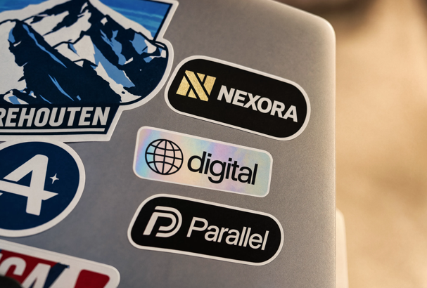 Close-up of multiple branded custom stickers applied to a laptop lid