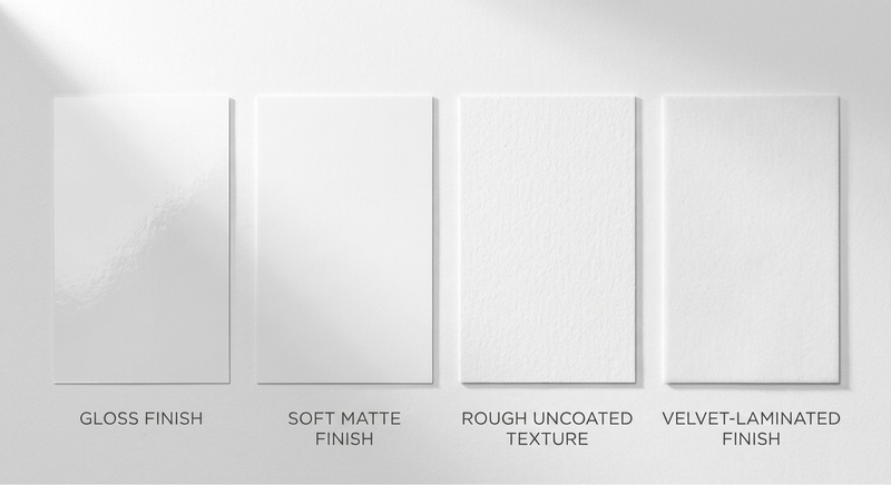 Four paper finish samples labelled gloss, matte, uncoated and velvet lamination on dark green felt surface