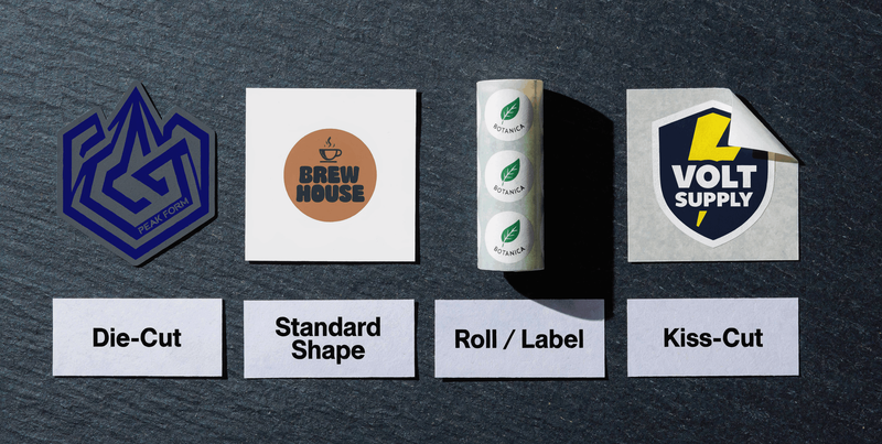 Eight sticker samples showing different cut formats including circle rectangle oval die cut and kiss cut arranged on dark slate surface
