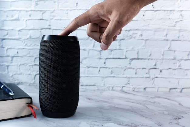 Man's hand using smart speaker on table .