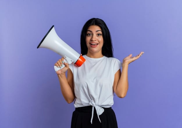 Surprised young caucasian girl holds loud speaker and raises hand up