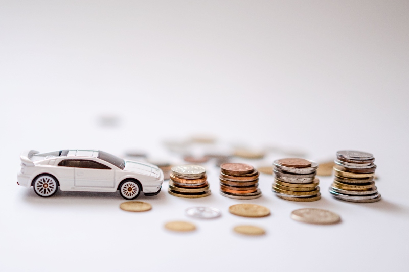 Free Sports Car Toy Beside the Pile of Coins Stock Photo