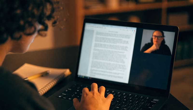 live English writing session: instructor reading a child's written paragraph on a shared screen and giving specific, real-time feedback