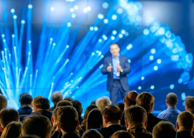 This may contain: a man standing on top of a stage in front of a crowd