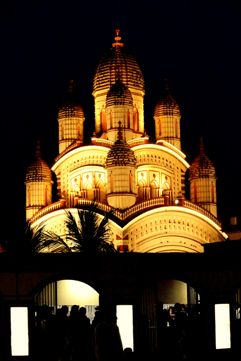 A beautifully lit image of the Dakshineshwar Kali Temple in Kolkata at night.