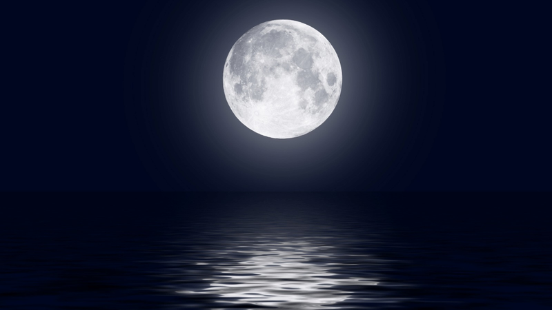 An HD image of the full moon over a water body.
