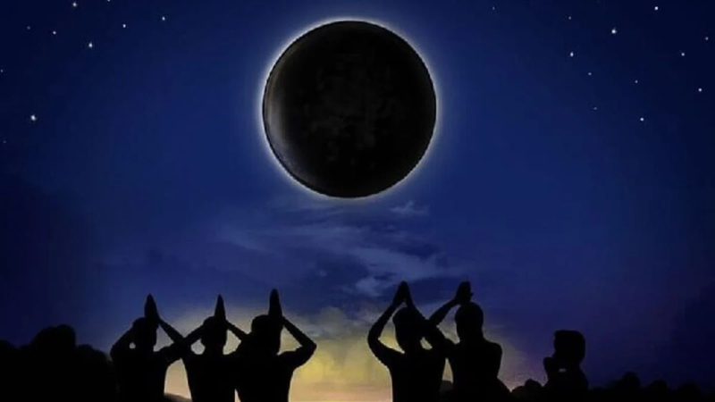 An illustration showing silhouettes of people praying to the Amavasya moon.