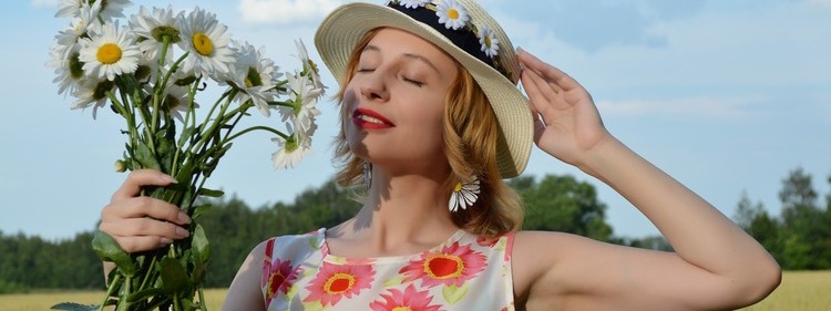 Woman holding flowers under open sky