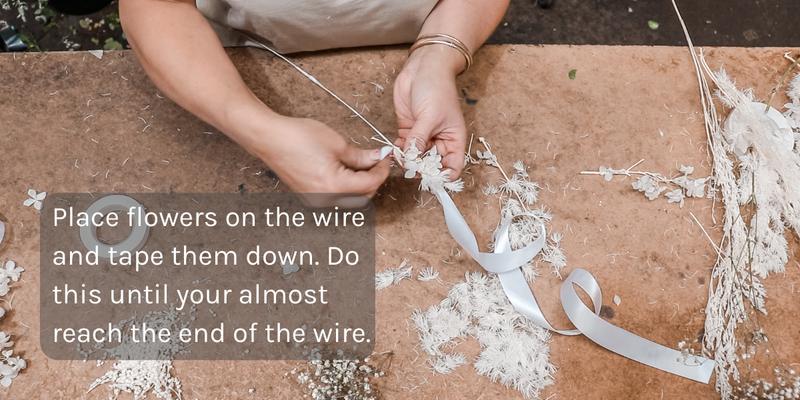 Placing flowers on the wire to make a flower crown
