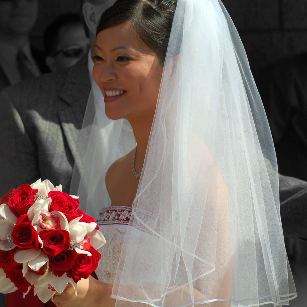 Bride holding a red rose bouquet