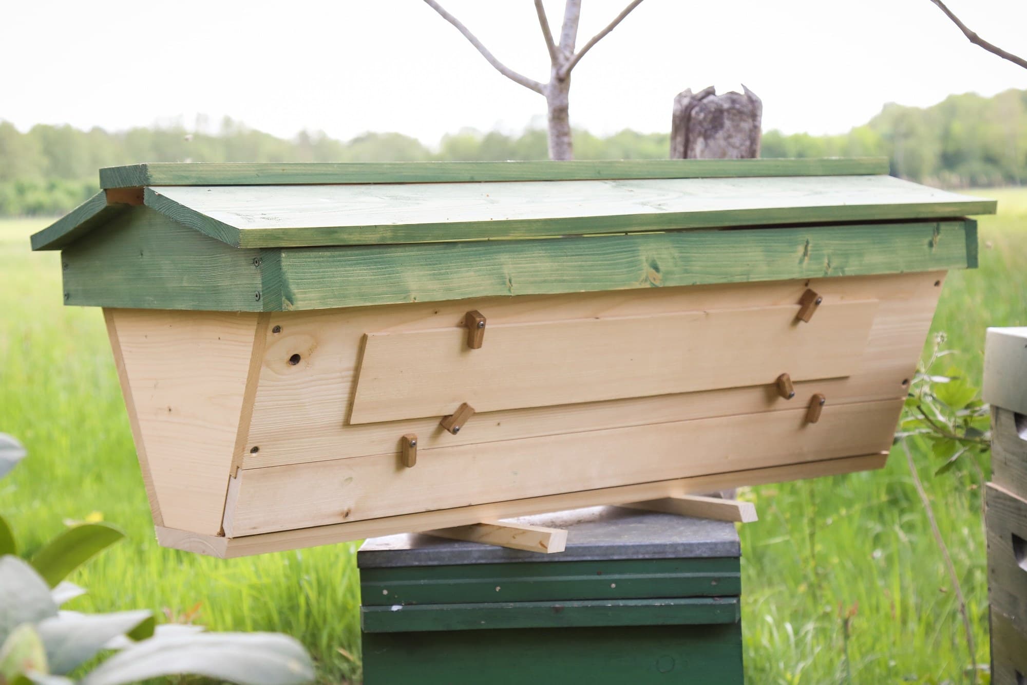 Wooden top bar hive in a meadow