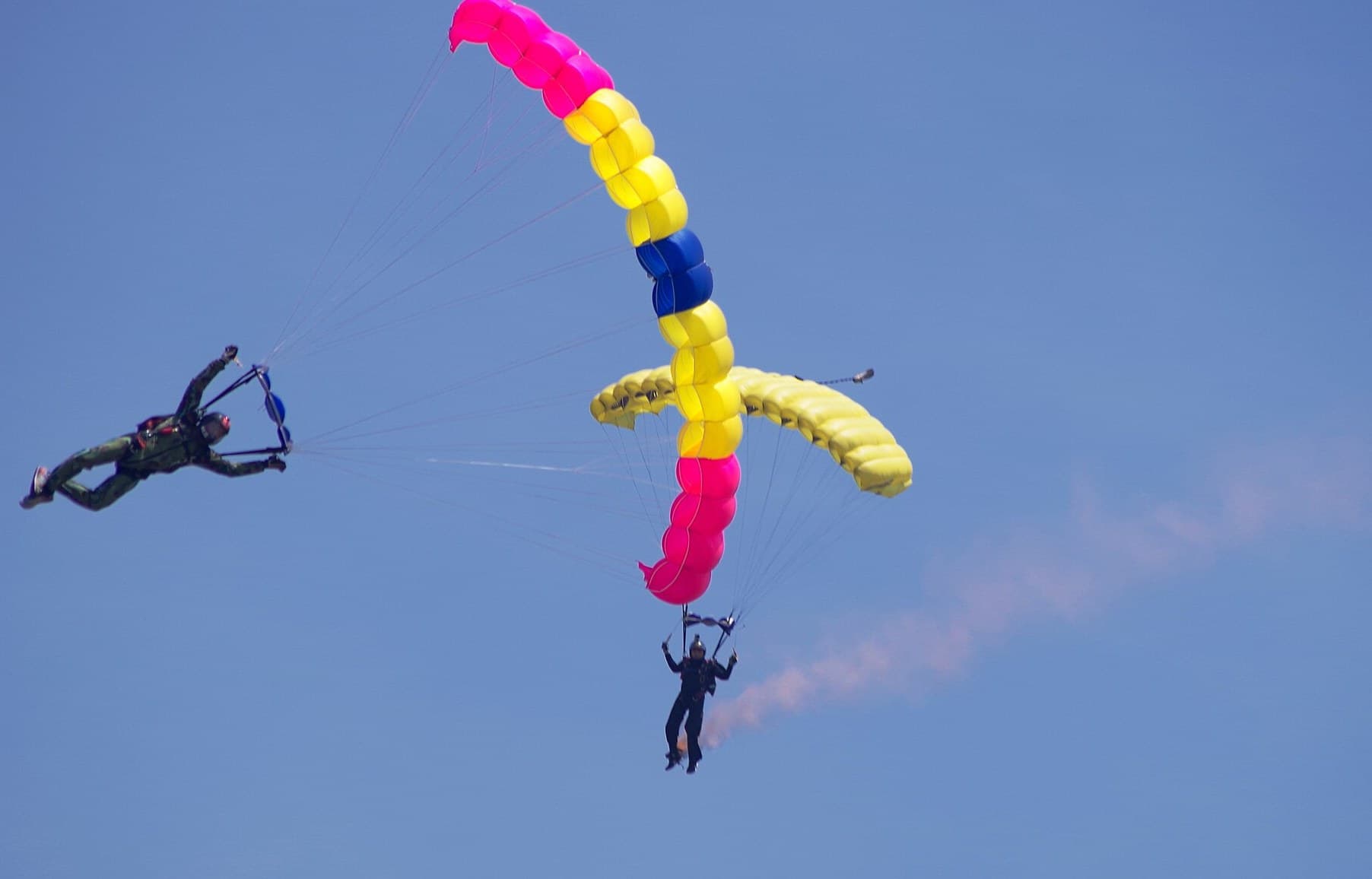 Skydiver under a colourful parachute canopy