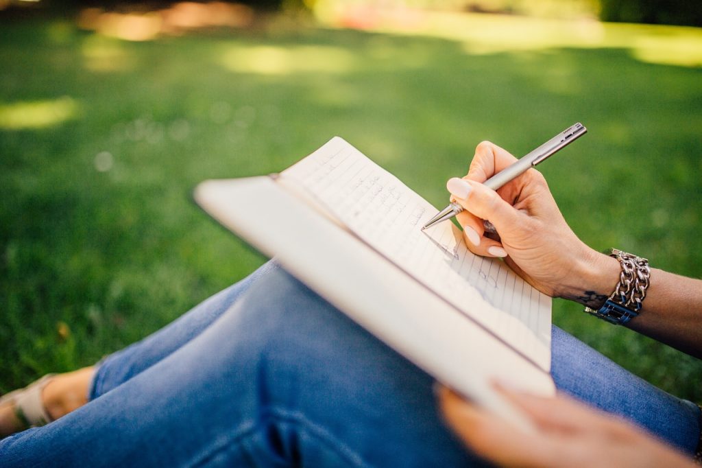 Writing notes outside with green grass background